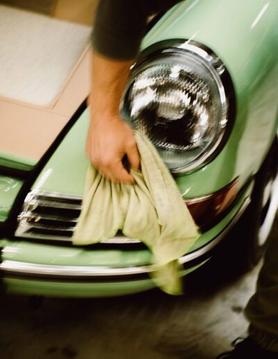 A green Revolt Electric headlight being polished by hand