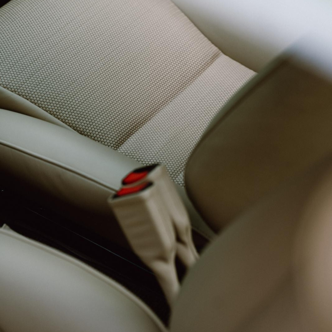 Cream seat upholstery and a red seat-belt buckle