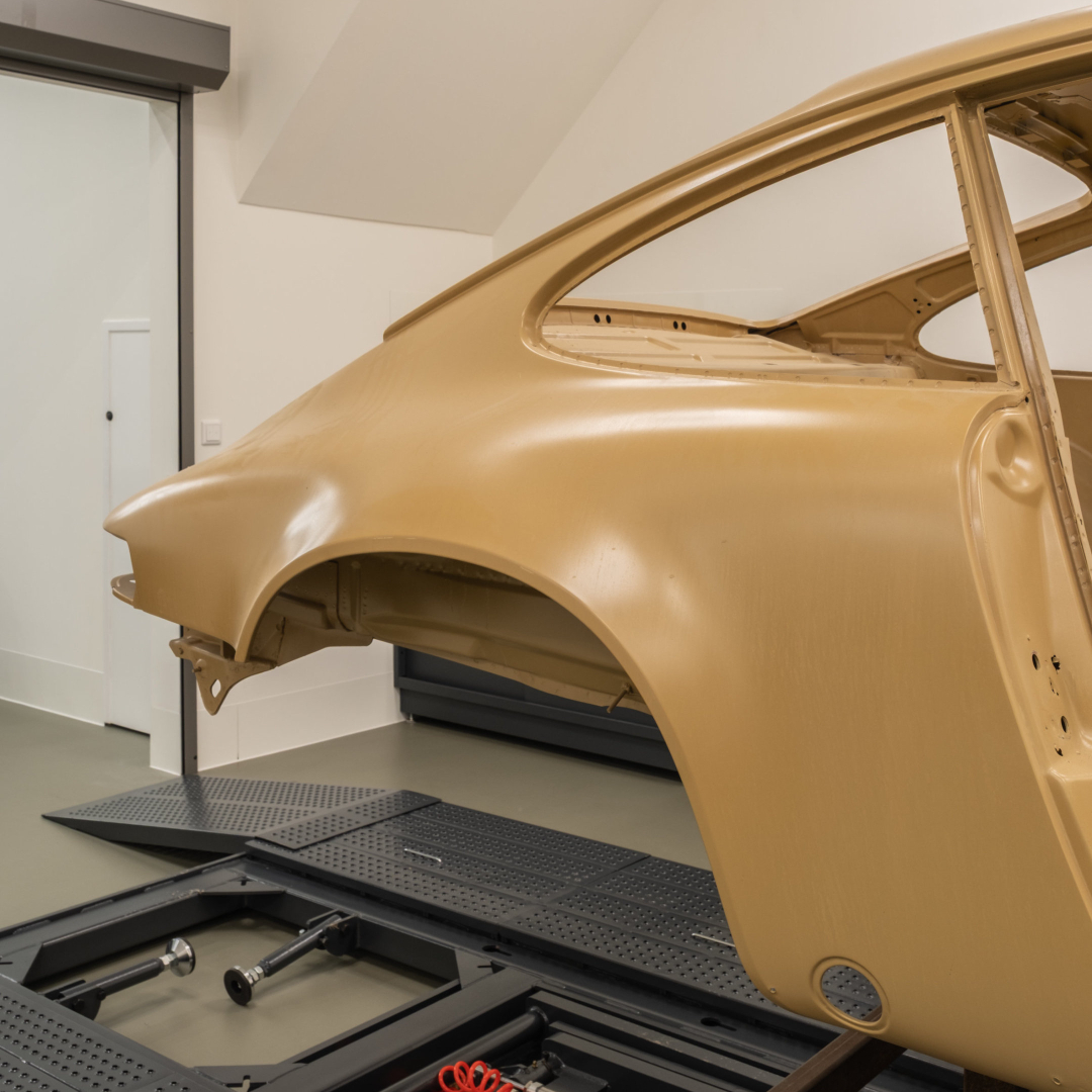 Bare vehicle body shell on a support frame in the atelier