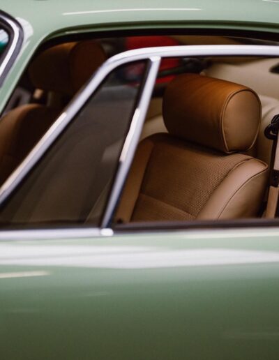 Tan leather seats viewed through the window of a green Revolt Electric