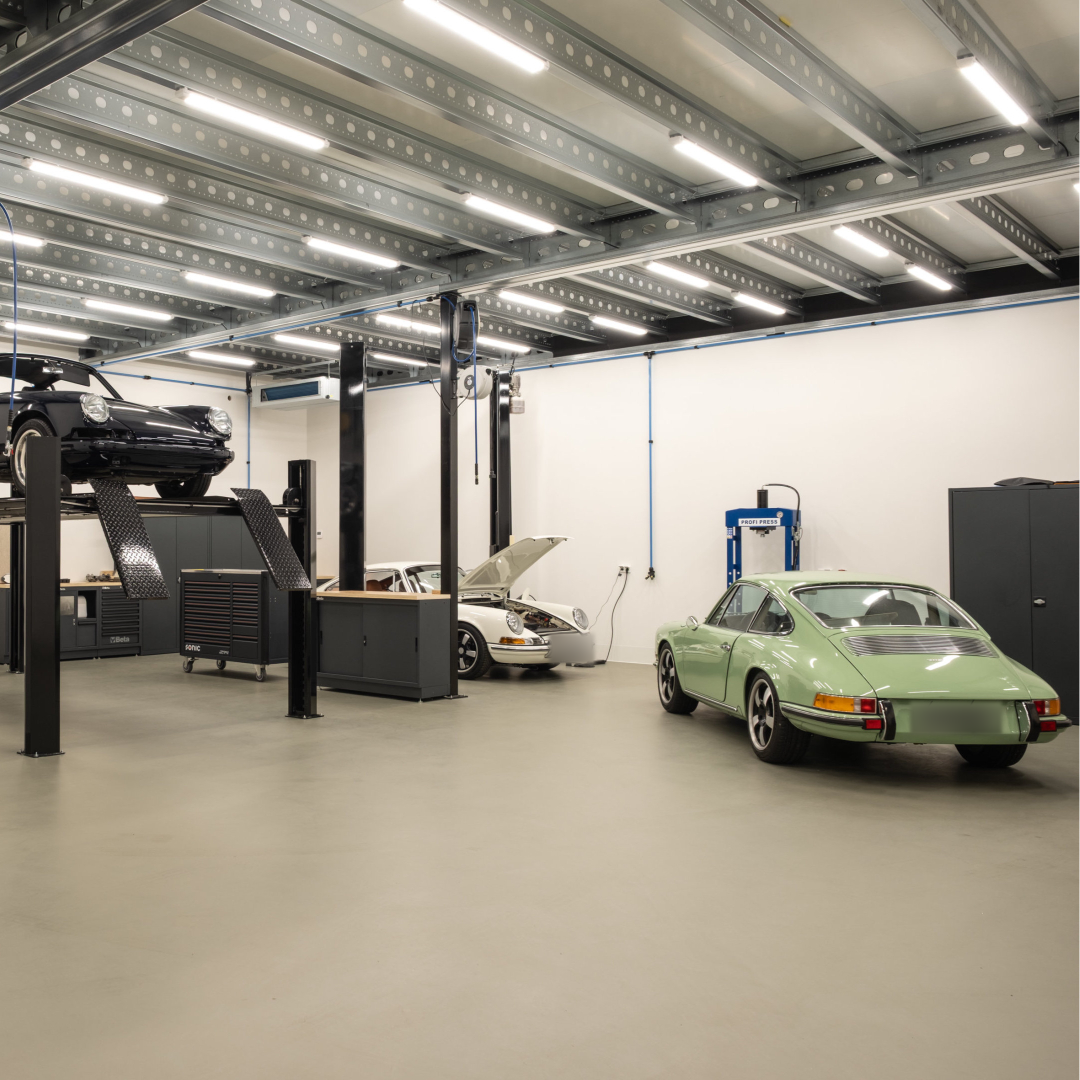 Vehicles and a raised chassis inside the Revolt Classics atelier