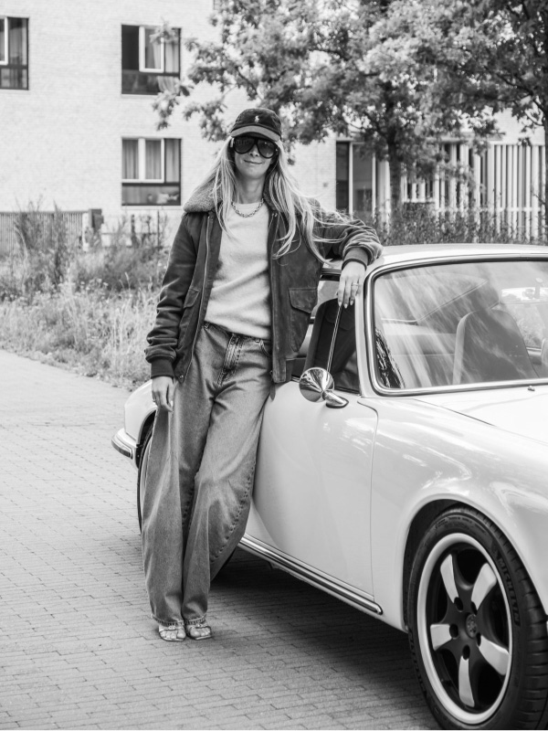 Woman standing beside a white Revolt Electric on a city street