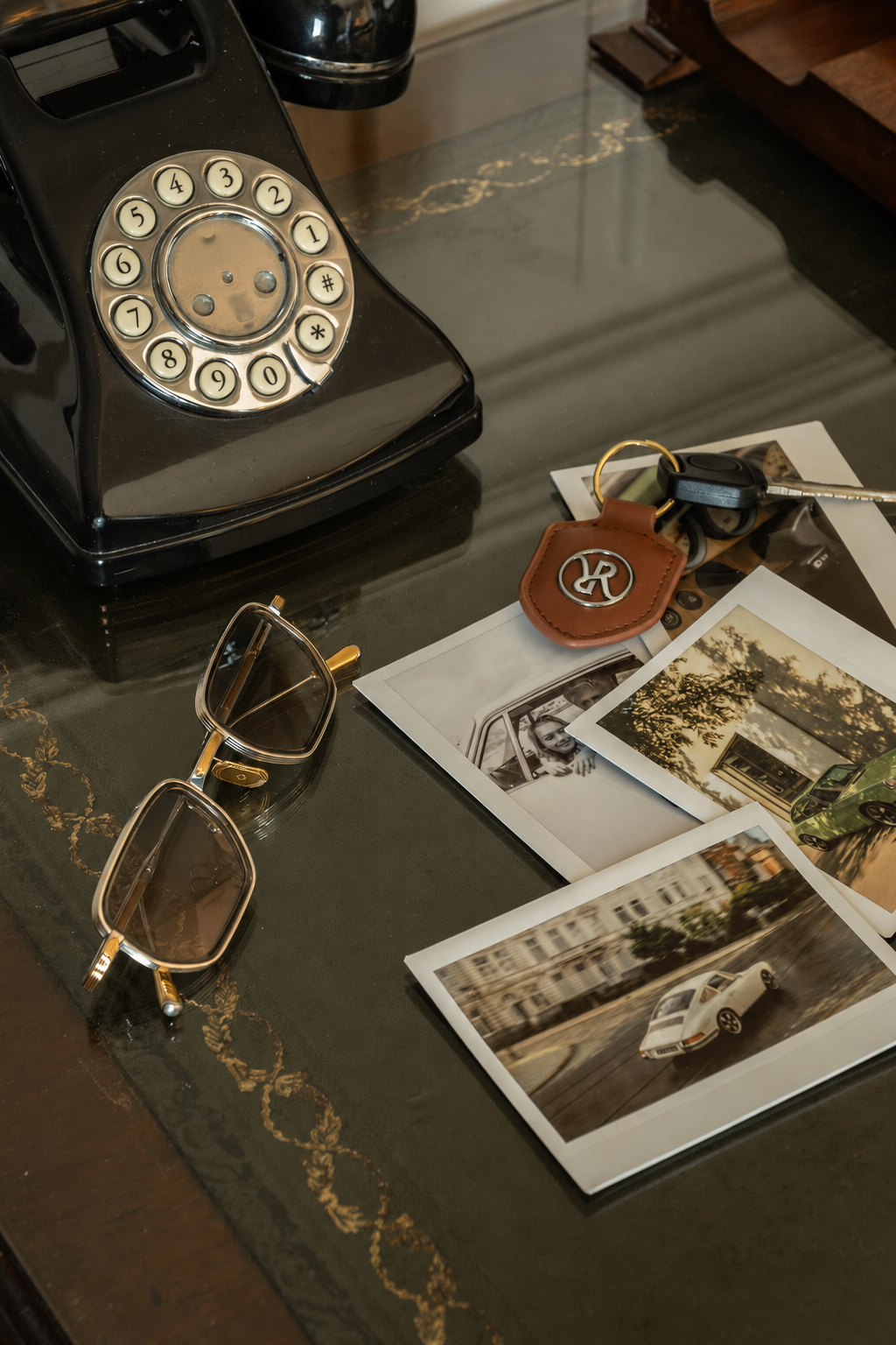 Leather key fobs, a watch and photographs on a tabletop